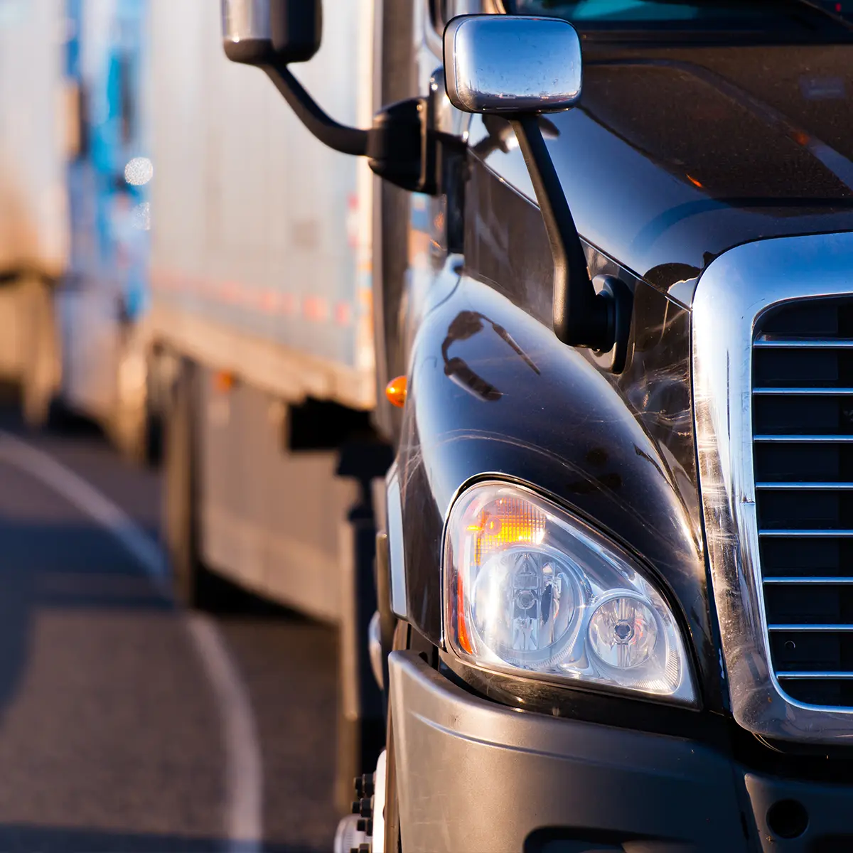 Close-up of a black semi-truck on the road, representing TurboTrack’s real-time asset tracking with Motorola radios and satellite technology.