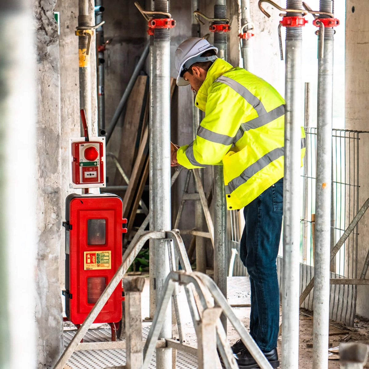 High-visibility worker using WES3 battery-powered emergency system on a construction site.