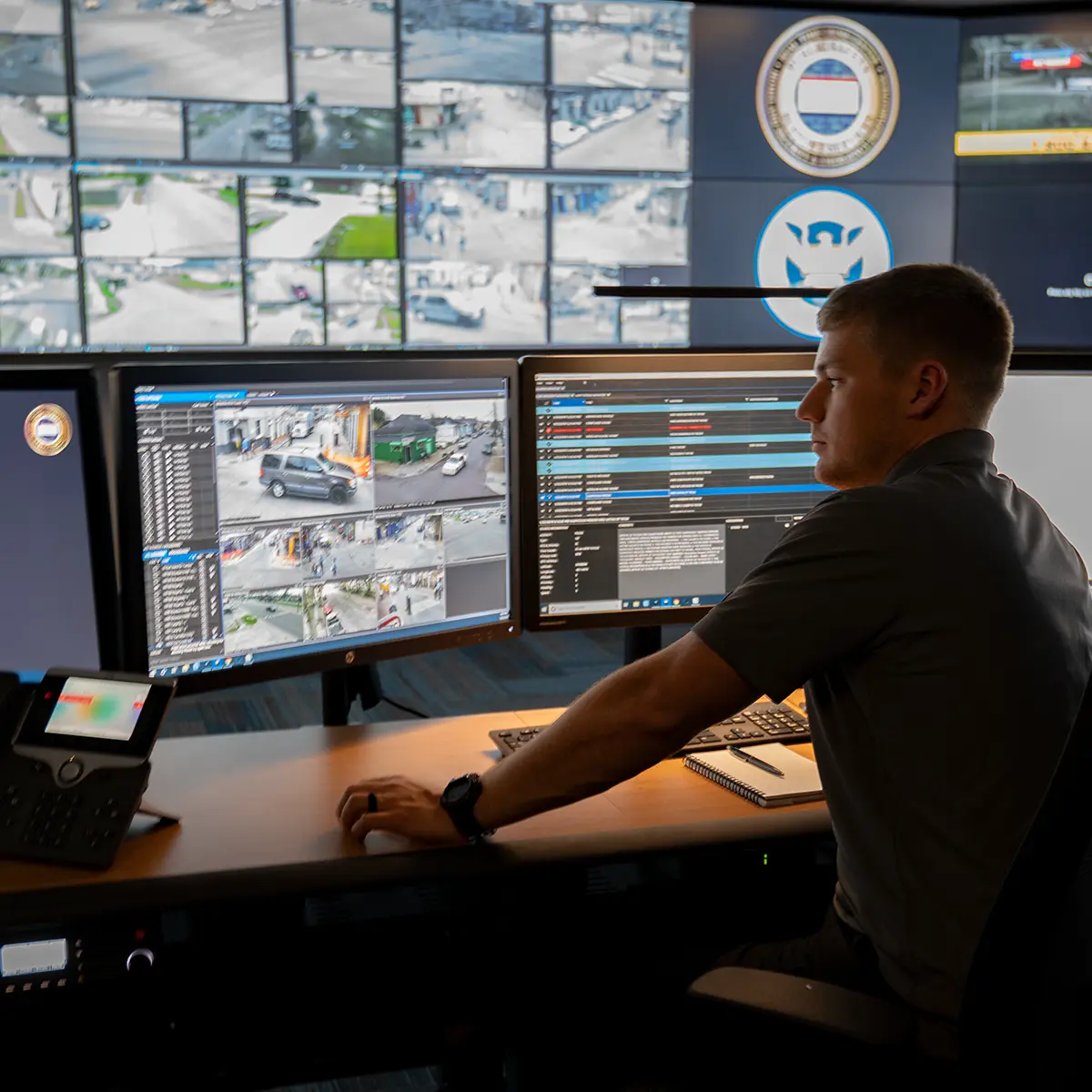 Desk setup with live camera feeds and data dashboards, illustrating tailored asset management tools for complex operational environments.