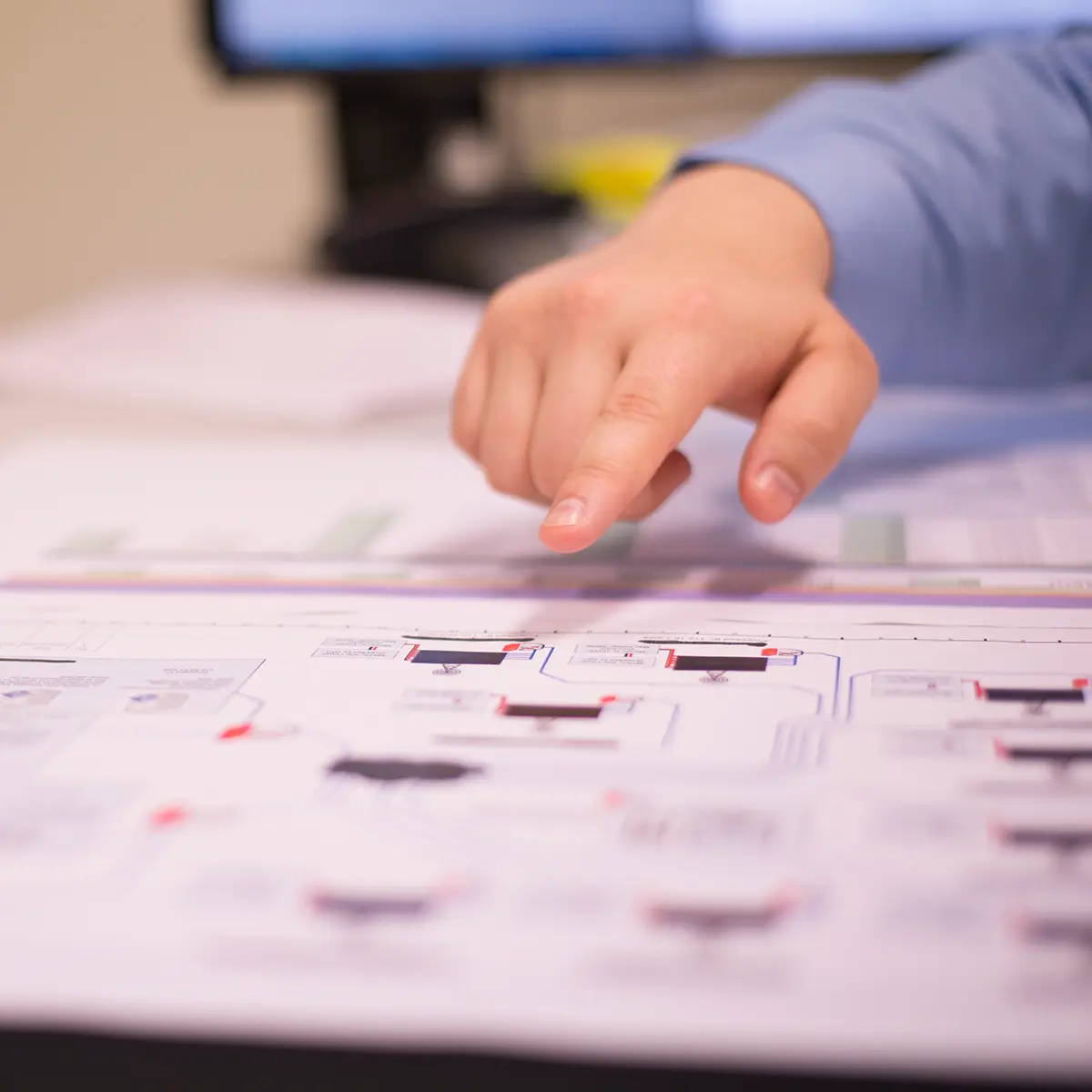 Detailed blueprint of a telecommunications system being reviewed in a workspace environment.