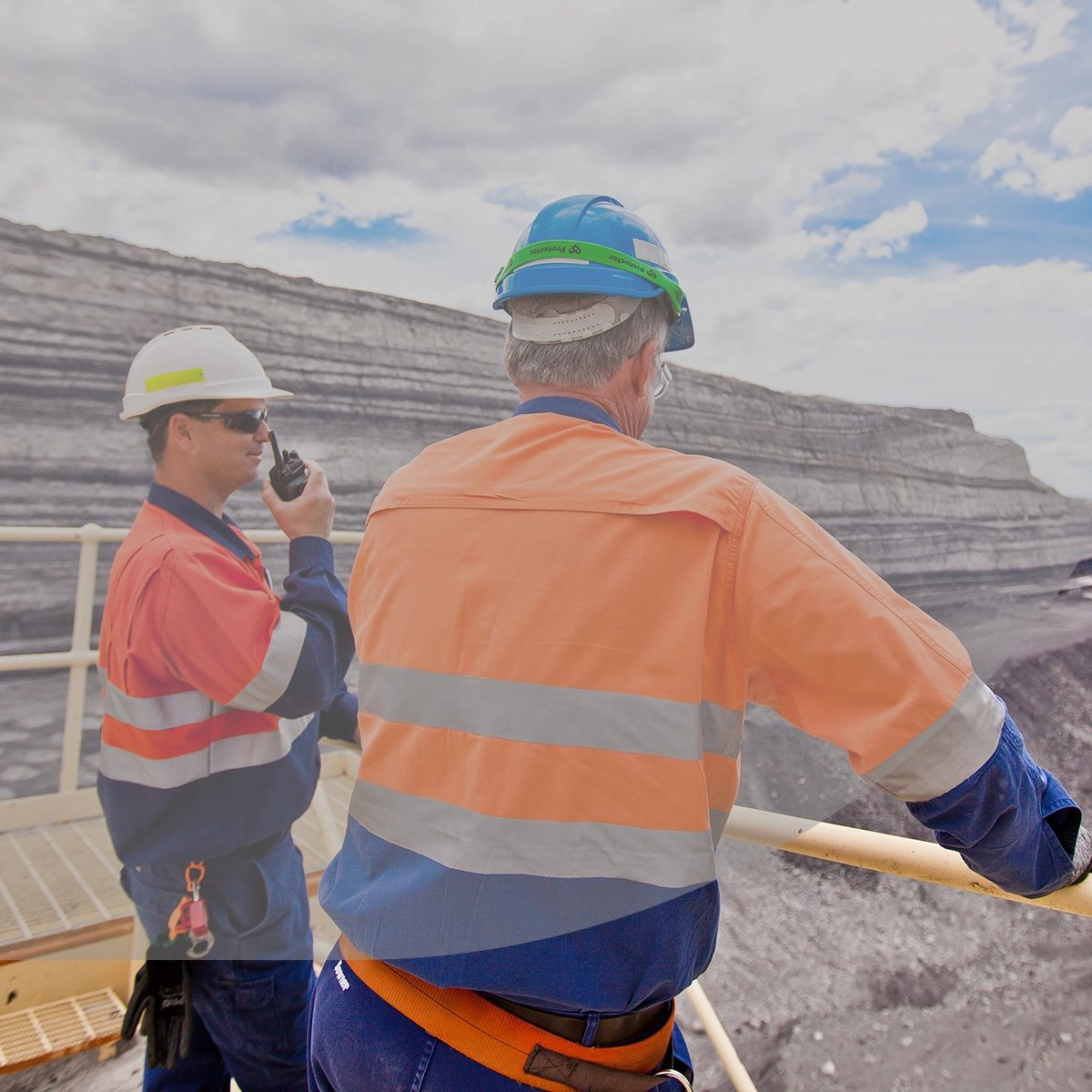 Two mine site operators use a two-way radio to communicate.