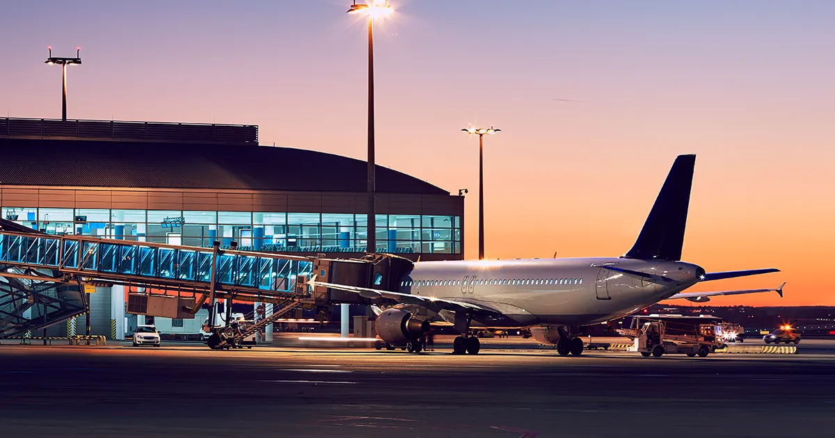 Airline carrier waits at a terminal for passengers to embark at sunset