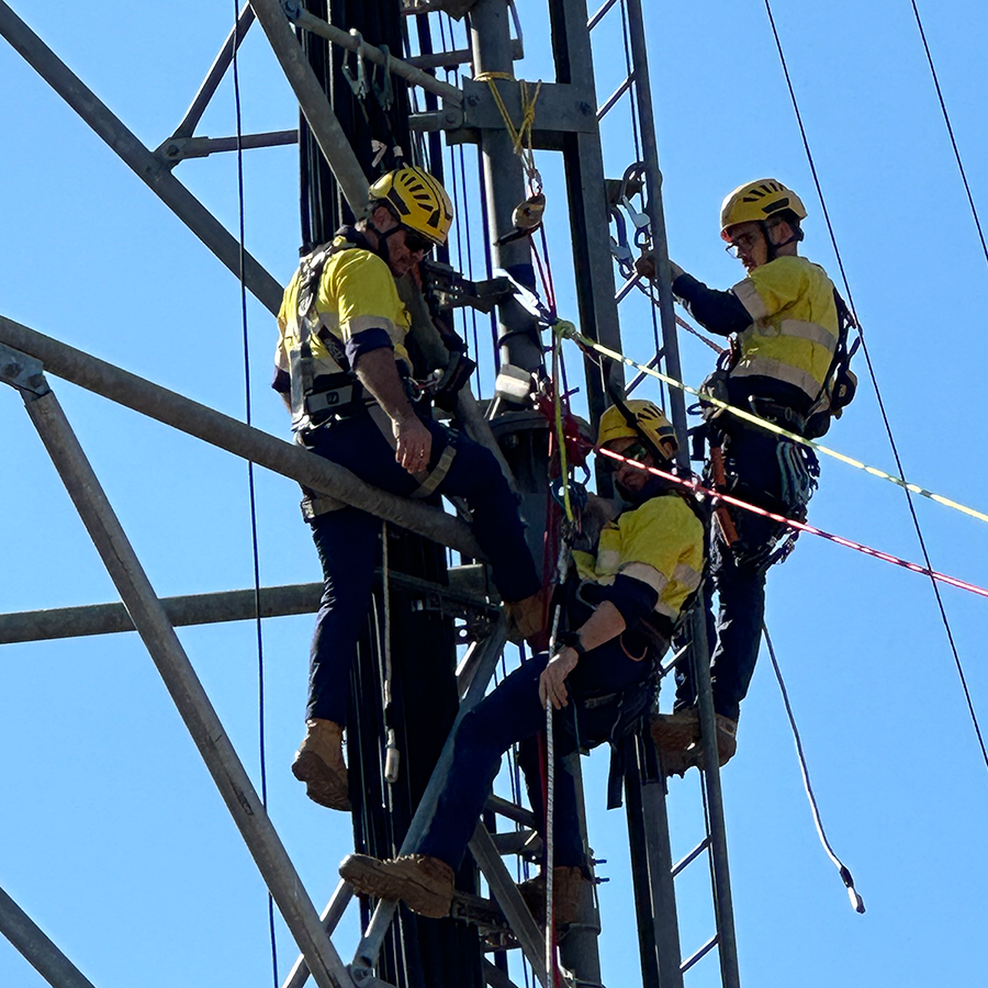 Three CSE Crosscom Technicians work with safety harnesses on a telecommunications tower.