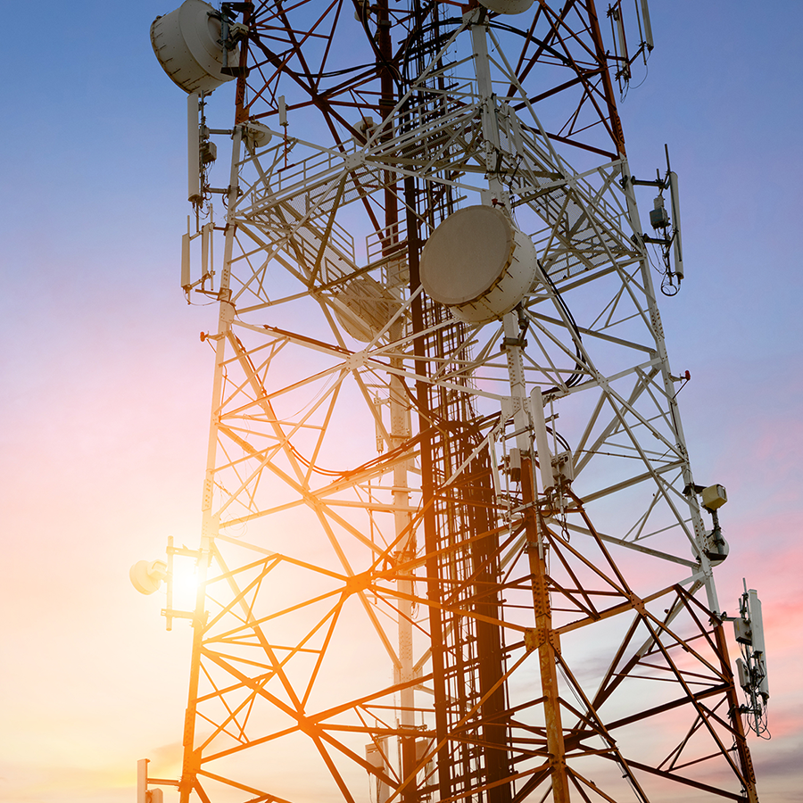 Radio Communications tower is backlit against a colourful sunset.