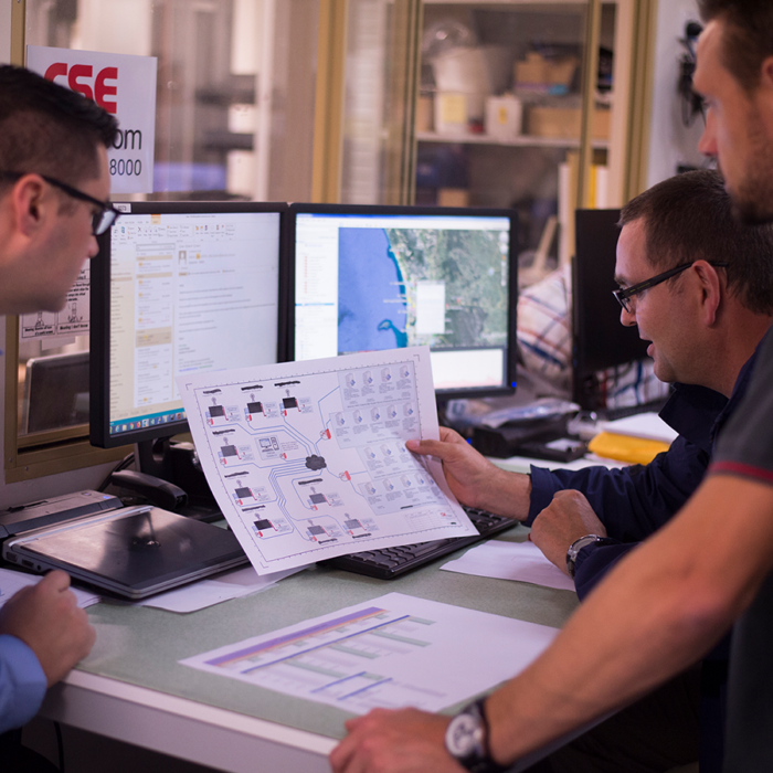 CSE Crosscom technicians consult schematics to help design a custom communication solution for clients.
