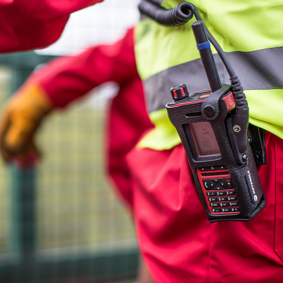 Motorola Solutions two-way radio in focus on a utilities workers' toolbelt.