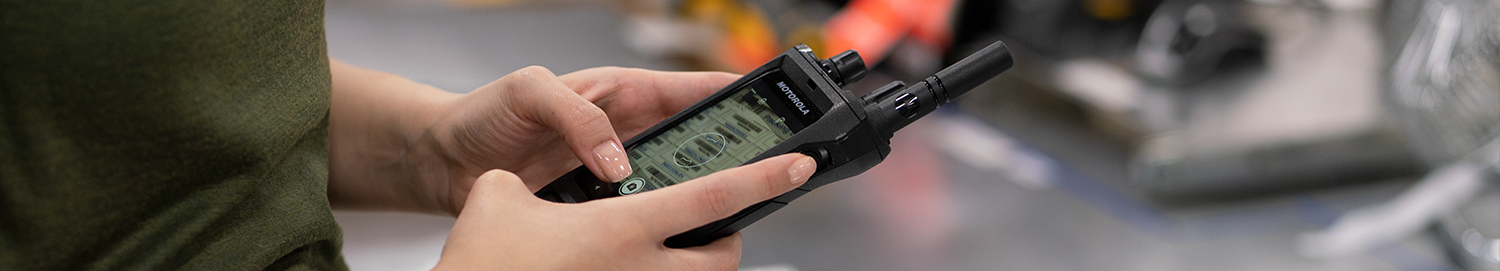 Manufacturing employee takes a photo of shelf stock using the Motorola Solutions MOTOTRBO ion Elgin 2 two-way radio .
