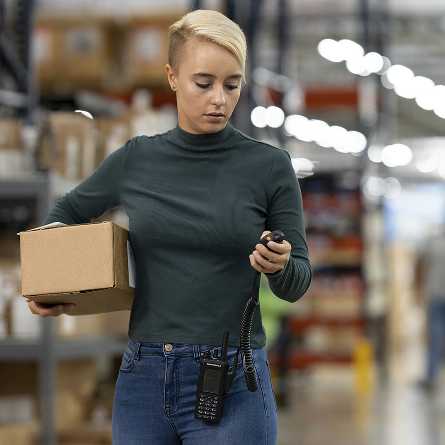 Manufacturing staff member grabs a Motorola Solution's two-way radio receiver to contact their team.