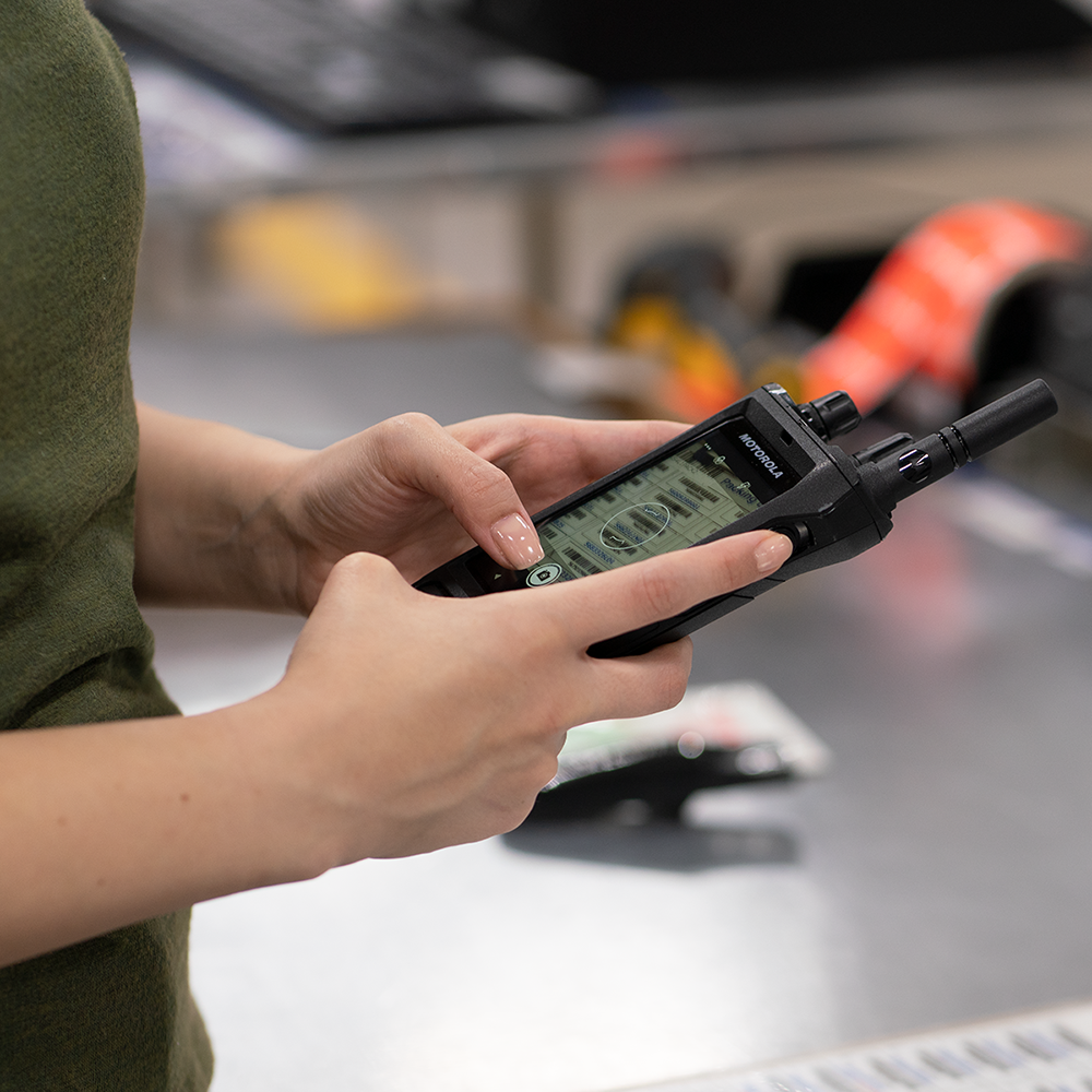 Woman uses the Motorola Solutions MOTOTRBO Ion smart radio to take a photo to send off to a team for review.